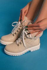Naklejka premium Beautiful girl with smooth legs in winter boots on a blue background