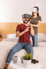 Technology innovation. Vigorous emotional young couple having fun with VR headsets while man screaming and gesturing