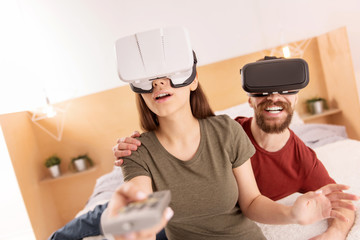 Try this. Innocent nice beautiful woman holding remote control while using VR glasses and wondering