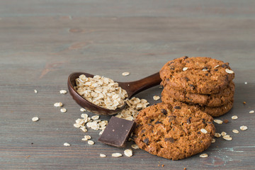 Delicious homemade pastries. Oatmeal cookies and a wooden spoon with oat flakes on an old table.