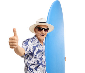 Naklejka premium Elderly tourist holding a surfboard and making a thumb up sign