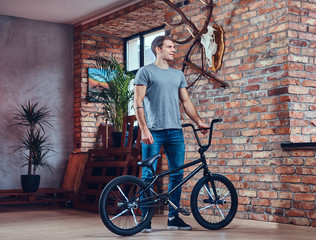 A handsome man with BMX in a studio.
