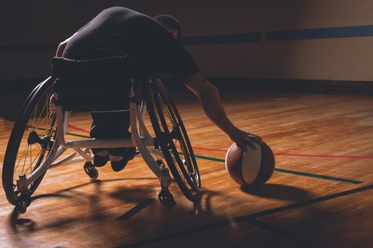 Disabled man practicing basketball in the court