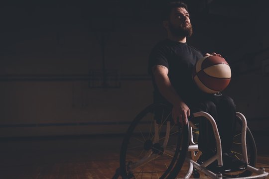 Disabled man practicing basketball in the court