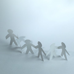group of paper men holding each other's hands