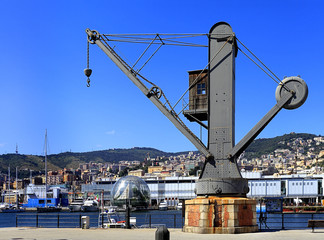 Genoa, Liguria / Italy - 2012/07/06: panoramic view on the port and city of Genoa - historic port crane by Tannet & Walker