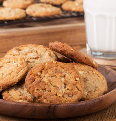 Closeup of a plate of peanut butter cookies and glass of milk in background