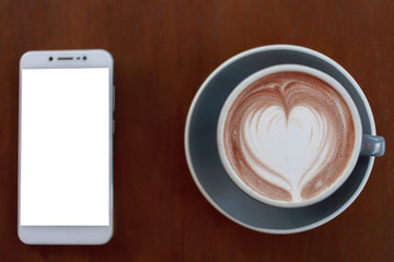 Top view cup of hot coffee latte art heart-shaped wooden floor.