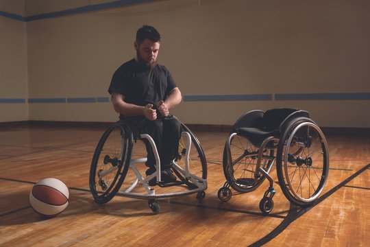 Disabled man adjusting belt of wheelchair