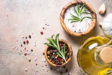 Spices and herbs background - olive oil rosemary on stone table.
