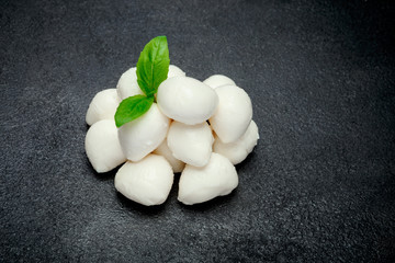 Traditional Italian Mozzarella cheese and basil on dark concrete