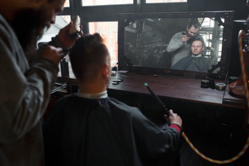 Barber cutting hair of customer. Smal business