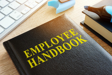 Employee handbook on a wooden desk. - obrazy, fototapety, plakaty