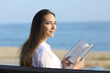 Woman reading a book and looking at camera