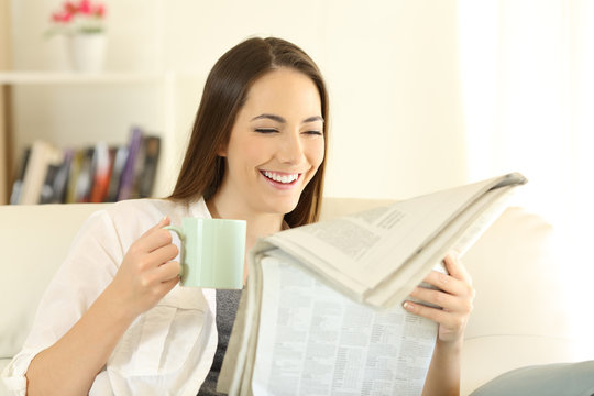 Woman reading a newspaper and holding a coffee cup