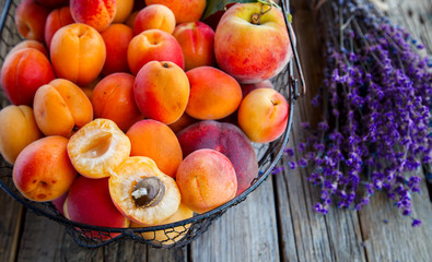 Naklejka na ściany i meble Apricots, Fruits in a metal basket on a vintage wooden background.Lavender, Flowers Bouquet.Food or Healthy diet concept.Super Food.Vegetarian.Copy space for Text.selective focus.