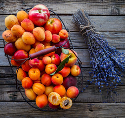 Apricots, Fruits in a metal basket on a vintage wooden background.Lavender, Flowers Bouquet.Food or Healthy diet concept.Super Food.Vegetarian.Copy space for Text.selective focus.