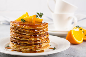 Homemade breakfast or brunch: american style pancakes served with orange and sprinkled caramel  syrup