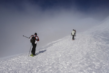 Fototapeta na wymiar alpinisti tra le nubi verso la cima di Piazzo - alpi Orobie
