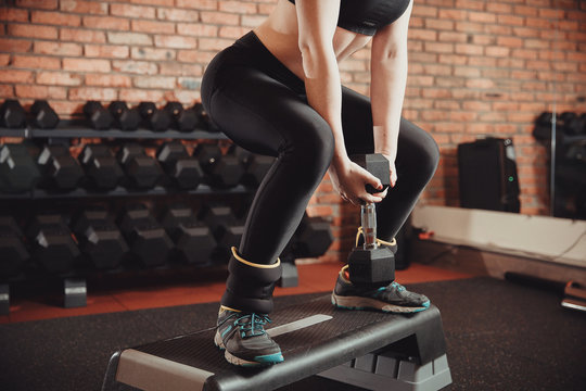 Young Sportive Woman Exercising In Gym Using Step Platform With Weighting. Concept Of Weight Loss