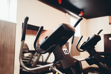 Exercise bikes stand in a row, treadmills in the gym, loft style