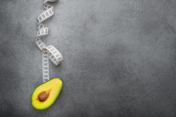 Fototapeta na wymiar Fresh avocado fruit with white measuring tape