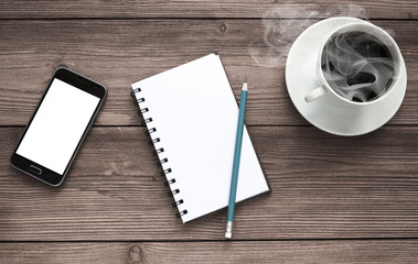 smartphone with a white screen, notebook, pencil. cup of coffee on a wooden background. coffee break. planning.