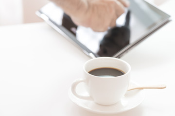 Cup of coffee and modern touch screen notebook.