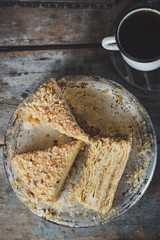 cake - Napoleon (cake with white cream is layered) and photos on a wooden table
