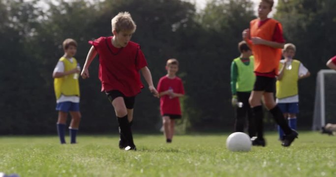 Kids training with a soccer ball on a field. Shot in slow motion on RED Epic.