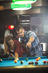 Young couple in a billiard club flirting