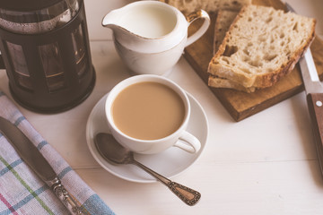 Fast breakfast, coffee with milk and fresh pastries, French press - top view