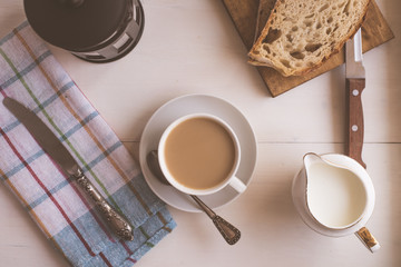 Fast breakfast, coffee with milk and fresh pastries, French press - top view