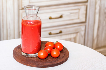Glass bottle of tomato juice with fresh tomatoes