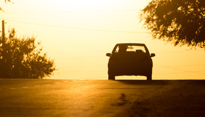 Fototapeta na wymiar car rides on the road at sunset