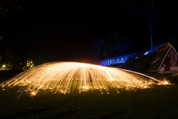 Steel wool light painting in the dark which looks like light umbrella with train track is in the...