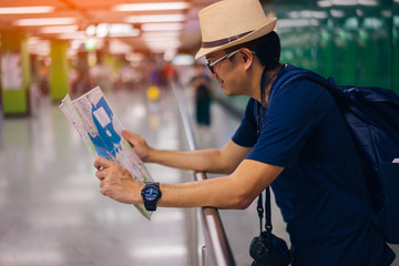 Young man asian traveler looking map at Hong Kong subway station MTR