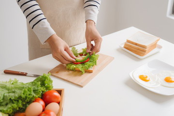 Hands of man prepare sandwich at home.
