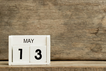 White block calendar present date 13 and month May on wood background