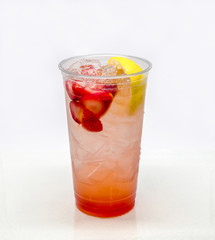 Strawberry Lemonade in a clear plastic cup on a white background.