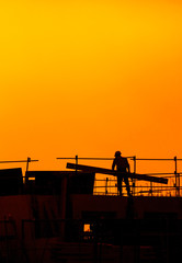 building workers working on a building under a sunset