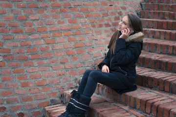 Fototapeta na wymiar Teenage girl talking on the smartphone outside