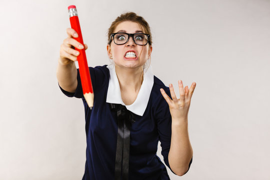 Angry woman holds big pencil in hand