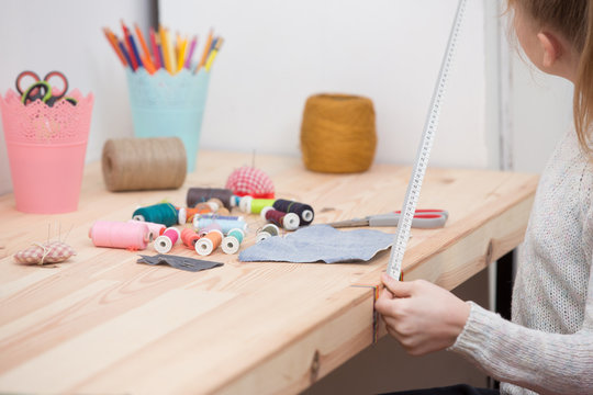 girl sews doll clothes, Child sewing 
