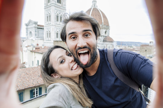 Loving couple taking a selfie in front of the church Santa Maria del Fiore, Florence Cathedral