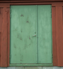 Red wall with old green door