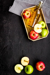 Bottle of fresh cider near autumn apples. Black background top view space for text