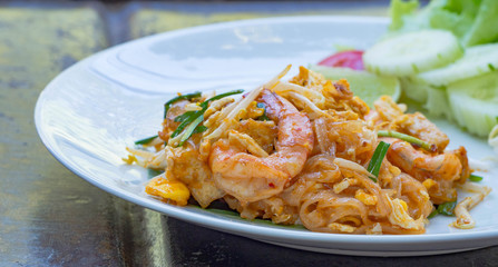 Pad thai with prawn serve in white plate with vegetable