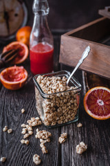 close up view of granola and fresh pomegranates fruit on wooden tabletop