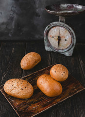 close up view of loafs of bread and old fashioned scales on wooden surface